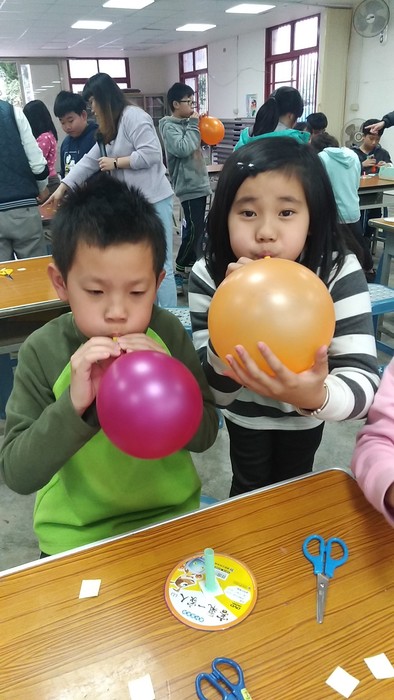 用力地給氣球吹氣準備比賽